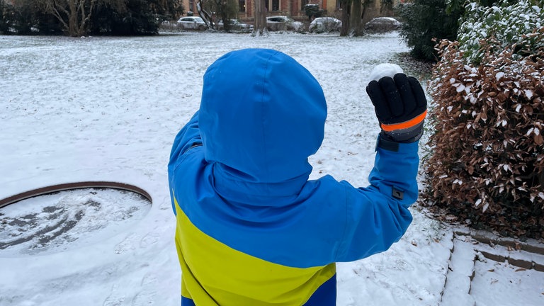 In der Pfalz liegt viel Schnee. Straßen, Wege und Pflanzen sind bedeckt damit - Kinder spielen mit dem Schnee.