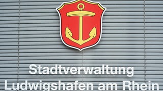 Stadtverwaltung Ludwigshafen: Ein heruntergelassener Sichtschutz hängt an einem Fenster mit dem Schriftzug "Stadtverwaltung Ludwigshafen am Rhein". 