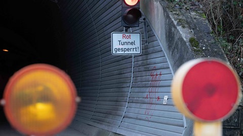 Eine rote Ampel mit dem Schild "Tunnel gesperrt" (Symbolbild). Die B10-Tunnel bei Annweiler bleiben wohl zweieinhalb Monate gesperrt.