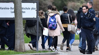 Schüler verlassen unter Polizeischutz die Karolina-Burger-Realschule in Ludwigshafen. Nach mehreren Zwischenfälle hatte die Polizei ihre Präsenz an der Schule erhöht.