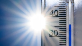 36 Grad Celsius zeigt ein Thermometer vor der Nachmittagssonne an (Symbolbild). Die Stadt Landau will insbesondere ihre Grundschulen und Kitas mit Geld aus dem Sondervermögen besser vor Hitze schützen.