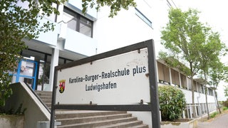 Schild und Gebaeude der Karolina-Burger-Realschule in Ludwigshafen am Rhein. 