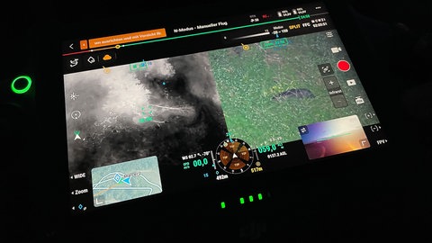 Auf dem Display der Drohnen-Fernbedienung kan man im Gelände eine Wildsau erkennen