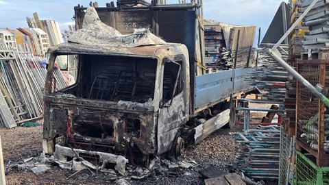 Ein ausgebrannter Lkw auf dem Gelände einer Firma in Grolsheim im Kreis Mainz-Bingen. Die Polizei ermittelt wegen Brandstiftung