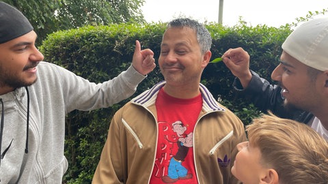 Murat Sözer ist streng und achtet auf gutes Benehmen. Er macht aber auch Spaß mit - selbst wenn Serif und Lutrim ihm ein Blatt ins Ohr stecken wollen. 
