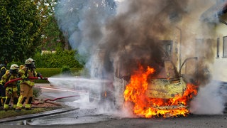 Feuerwehrleute löschen den brennenden Transporter in Simmertal.