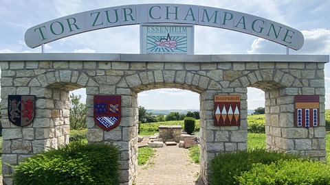 Ein Steintor - darüber ein Schild mit der Aufschrift "Das Tor zur Champagne": Ein beliebtes Ausflugsziel in Essenheim. Im Juni hatten Unbekannte die Steinbänke komplett zerstört. Jetzt sprechen die Bürgermeister darüber, wie sie gegen Vandalismus vorgehen können. 