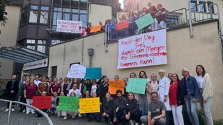 Mitarbeiter demonstrieren vor dem Mainzer Schmerzzentrum für den Erhalt der Klinik.