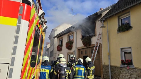 Rauch kommt aus dem Fenster eines Wohnhauses im in Schwabenheim. Davor steht ein Rettungswagen. 