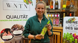 Janina Krick hält die von ihr entwickelte Weinflasche aus recycelbarem Plastik in der Hand.