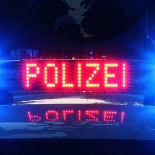 Ein Polizeiauto hat bei Nacht das Blaulicht an.