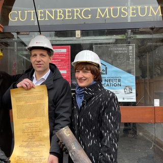 Der Direktor des Mainzer Gutenberg-Museums, Ulf Sölter, der Mainzer Oberbürgermeister Nino Haase und die scheidende Kulturdezernentin Marianne Grosse (v.l.n.r.) mit der Urkunde aus der Zeitkapsel des Gutenberg-Museums von 1961