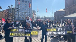 Schülerinnen und Schüler mit Bannern demonstrieren am Mainzer Hauptbahnhof gegen eine mögliche Wehrpflicht