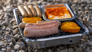 Drei jugendliche Mädchen grillen mit Einweggrill auf Autobahnbrücke und werfen Fleischreste auf A61 (Symbolbild).