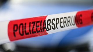 Absperrband der Polizei vor einem Streifenwagen: 