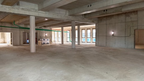Ein leerer Raum in einem Rohbau der neuen Anna Seghers-Bücherei in Mainz, Boden und Wände sind aus grauem Beton.