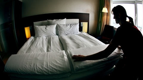 Ein Zimmermädchen macht ein Hotelbett. In Mainz gilt ab dem 1. Juli 2026 eine Bettensteuer. 
