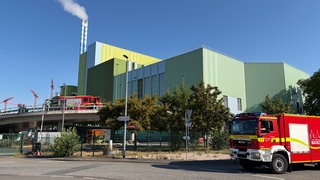 Zwei Einsatzfahrzeuge der Feuerwehr stehen vor dem Müllheizkraftwerk in Mainz.