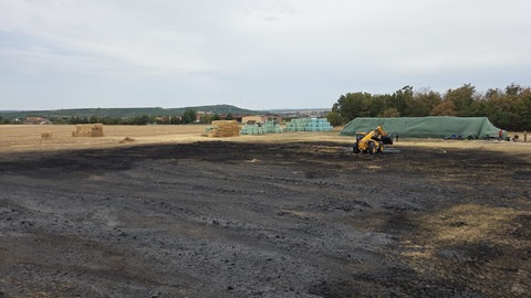 Nach dem Brand von 1.000 Strohballen bleibt ein schwarzes Feld zurück.