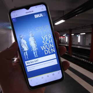 Ein Handy zeigt eine Suchmeldung nach vermissten Kindern.