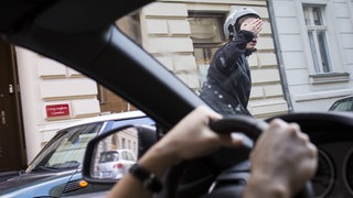 Ein Radfahrer beschwert sich bei einem Autofahrer. (Symbolbild) In Mainz ist ein Streit zwischen einem Auto- und einem Radfahrer eskaliert. 