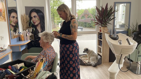 Julia Neumann, die Inhaberin des veganen Friseursalons in Waldlagesheim, legt die Haare ihrer Kundin Irene Mertens.