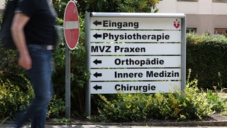 Auf einem Wegweiser sind verschiedene Praxen eines Medizinischen Gesundheitszentrums zu sehen (Symbolbild).