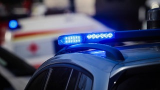 Blaulicht von einem Polizei- und einem Rettungswagen. (Symbol) Am Mainzer Hauptbahnhof sind drei verletzte Männer entdecktr worden. Die Polizei versucht zu klären, was passiert ist. 