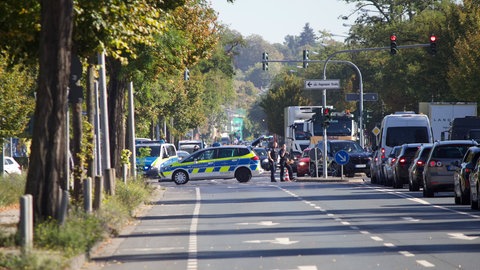 Einsatzkräfte sichern die Reanimation in der Wiesbadener Äppelallee vor Blicken von Gaffern ab.