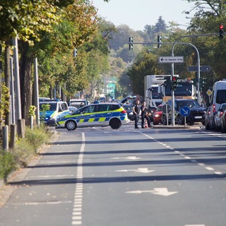 Einsatzkräfte sichern die Reanimation in der Wiesbadener Äppelallee vor Blicken von Gaffern ab.