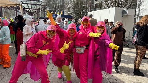 Auf dem Schleiferplatz in Idar-Oberstein feiern rund 350 Menschen Weiberfastnacht, auch die vier Damen in Rosa.