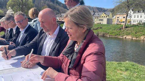 Julia Gieseking, Andreas Kruppert und Stefan Metzdorf unterzeichnen in Kordel den Kooperationsvertrag für einn verbesserten Hochwasserschutz an der Kyll. 