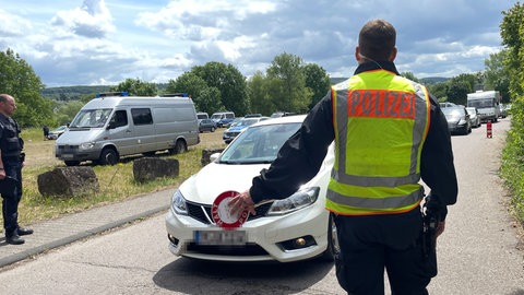 Polizist mit Kelle winkt Verkehrsteilnehmer heraus zur Kontrolle
