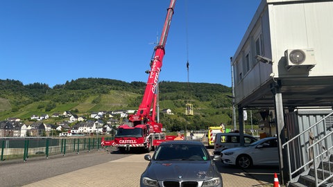 Mit einem Kran begutachten Experten die beschädigte Schleuse in St. Aldegund an der Mosel. 