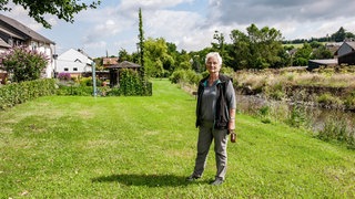 Familie Becker investiert viel, um ihr Grundstück frei von der Herkulesstaude zu halten. Auf dem anderen Uferbereich breitet sie sich ungehemmt aus.