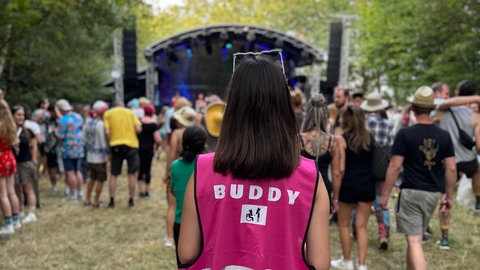 Nina Bohn mit einer pinken Warnweste, auf der Buddy steht