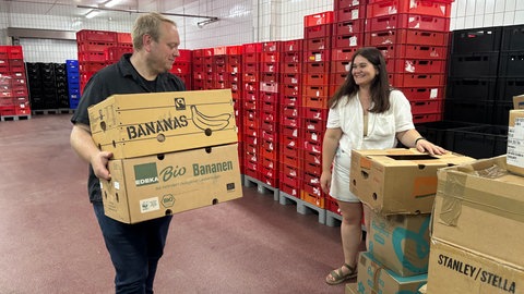 Anna Stetska und Tobias Schneider räumen Ukraine-Spenden in Säcke und Kisten.