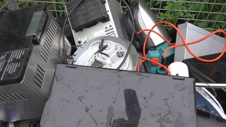 Im Müllcontainer sammeln die Schüler die kaputten Elektrogeräte