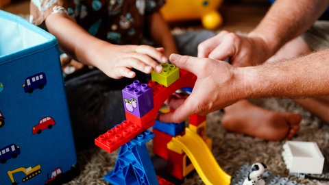 Ein Vater und ein Kind spielen mit Lego-Bausteinen