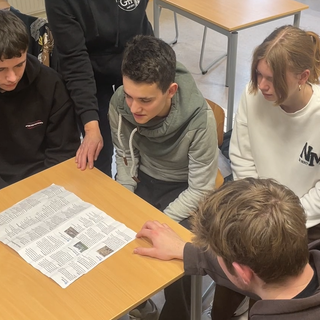Mehrere Schüler beugen sich über eine Karte. 