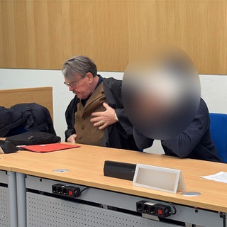 Der Angeklagte hat beim Prozessauftakt am Landgericht Trier ununterbrochen sein Gesicht mit Händen oder einem Blatt Papier verdeckt.