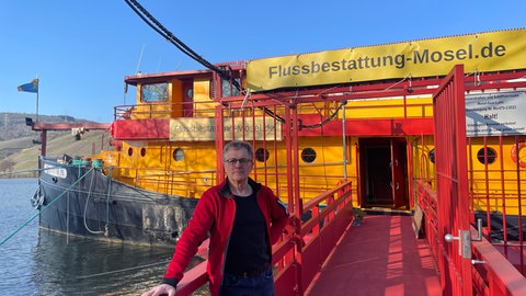 Viel Bürokratie, wenig Nachfrage - der Tod und Bestattungen im Fluss: Joachim Zimmermann hat sich in den 1990er-Jahren seinen Traum von einem eigenen Schiff erfüllt und das alte Postschiff gekauft. Jetzt bietet er an Bord auch Bestattungen auf der Mosel an. 
