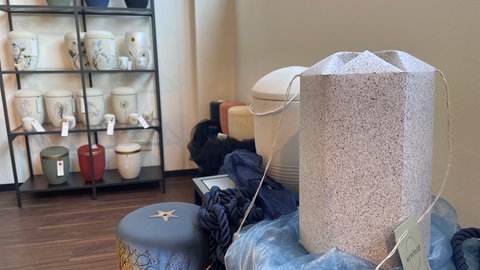 Viel Bürokratie, wenig Nachfrage - der Tod und Bestattungen im Fluss: Die Urne aus Algenpapier sieht unscheinbar aus, erfüllt aber ihren Zweck. Sie geht schnell unter und löst sich in der Mosel auf. 