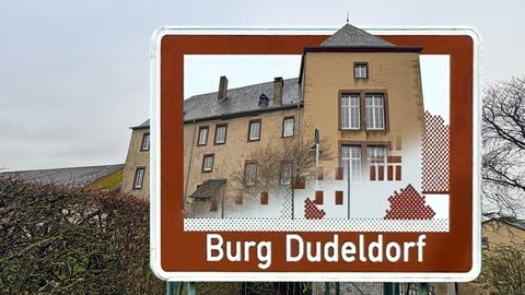 Braune Autobahnschilder weisen auf touristische Ziele, wie hier die Burg Dudeldorf - Schild und Realität stimmen hier gut überein.