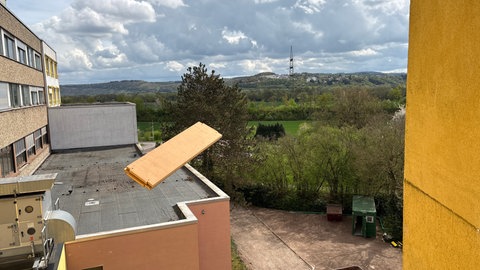 Dicke Bretter fliegen an einem Fenster im ehemaligen Krankenhaus Trier-Ehrang vorbei. Sie stammen von Schränken, die Bauarbeiter auseinandergenommen haben.