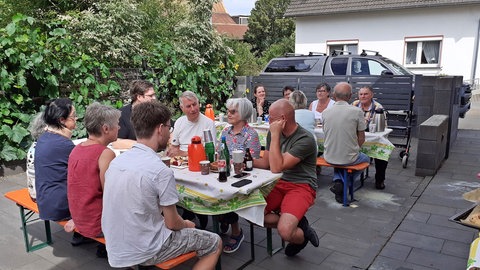 Anwohner in Jünkerath in der Eifel veranstalten nach Hochwasser im Jahr 2021 ein Straßenfest.