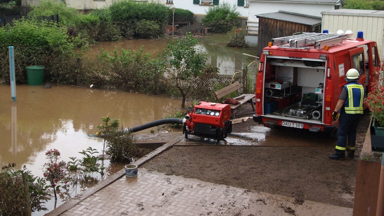 Die Feuerwehr pumpt nach dem Hochwasser in Jünkerath in der Eifel Wasser ab.