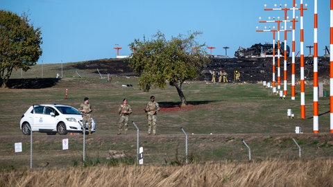US-Militärpolizisten stehen vor den Trümmern eines F16-Düsenjägers auf der Airbase Spangdahlem. 