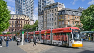Menschen steigen in Mainz in eine Straßenbahn ein. 
