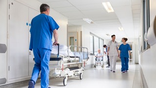 Blick in einen Krankenhausflur mit Pflegern und Plegerinnen. Was wollen die Parteien beim Thema Gesundheit. 